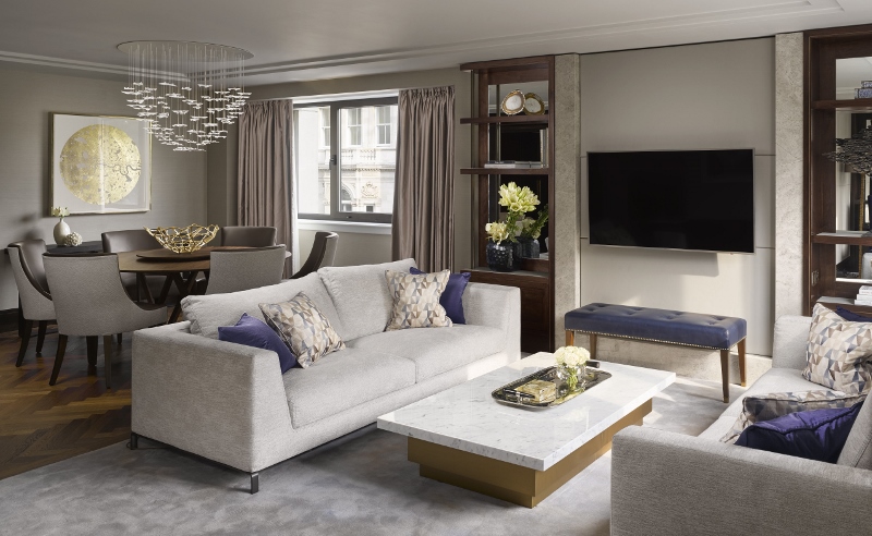 Light-grey sofa in living room with detailed chandelier above