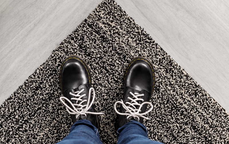Men;s feet on the edge of a carpet
