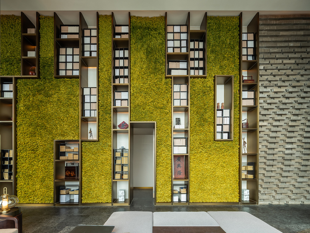 Living green wall inside the hotel - with integrated bookshelf