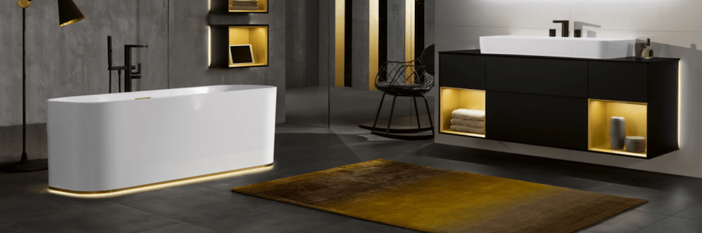 Modern and clean looking bathroom with gold accents of colour in furniture and under bath