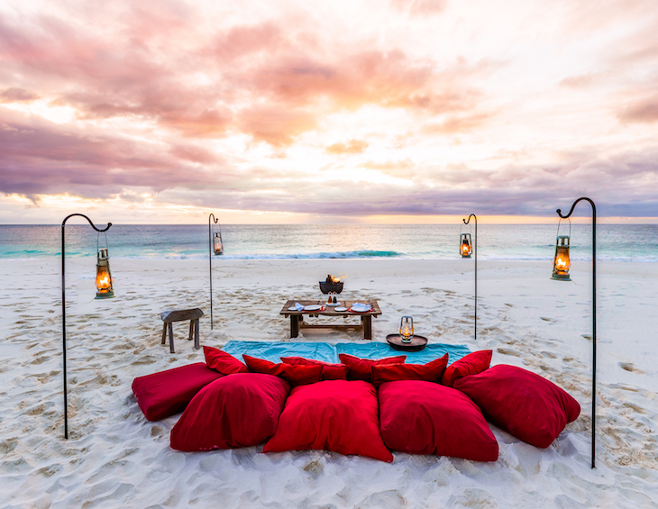 make-shift picnic with red cushions on the beach overlook undisturbed ocean
