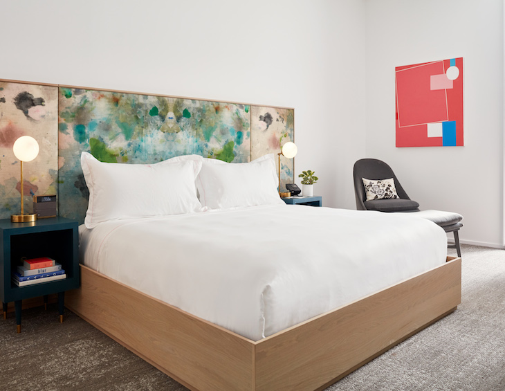 Modern guestroom with colourful accents in headboard and art