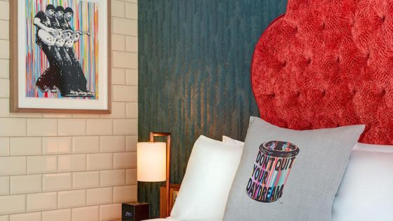 Red headboard, colourful art work and a white bed