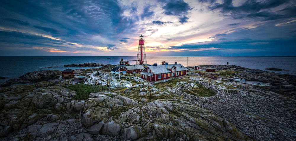 A dramatic view capturing the lighthouse and houses surrounding them
