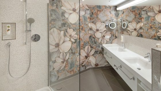 A bathroom with floral walls and modern shower unit from Kaldewei