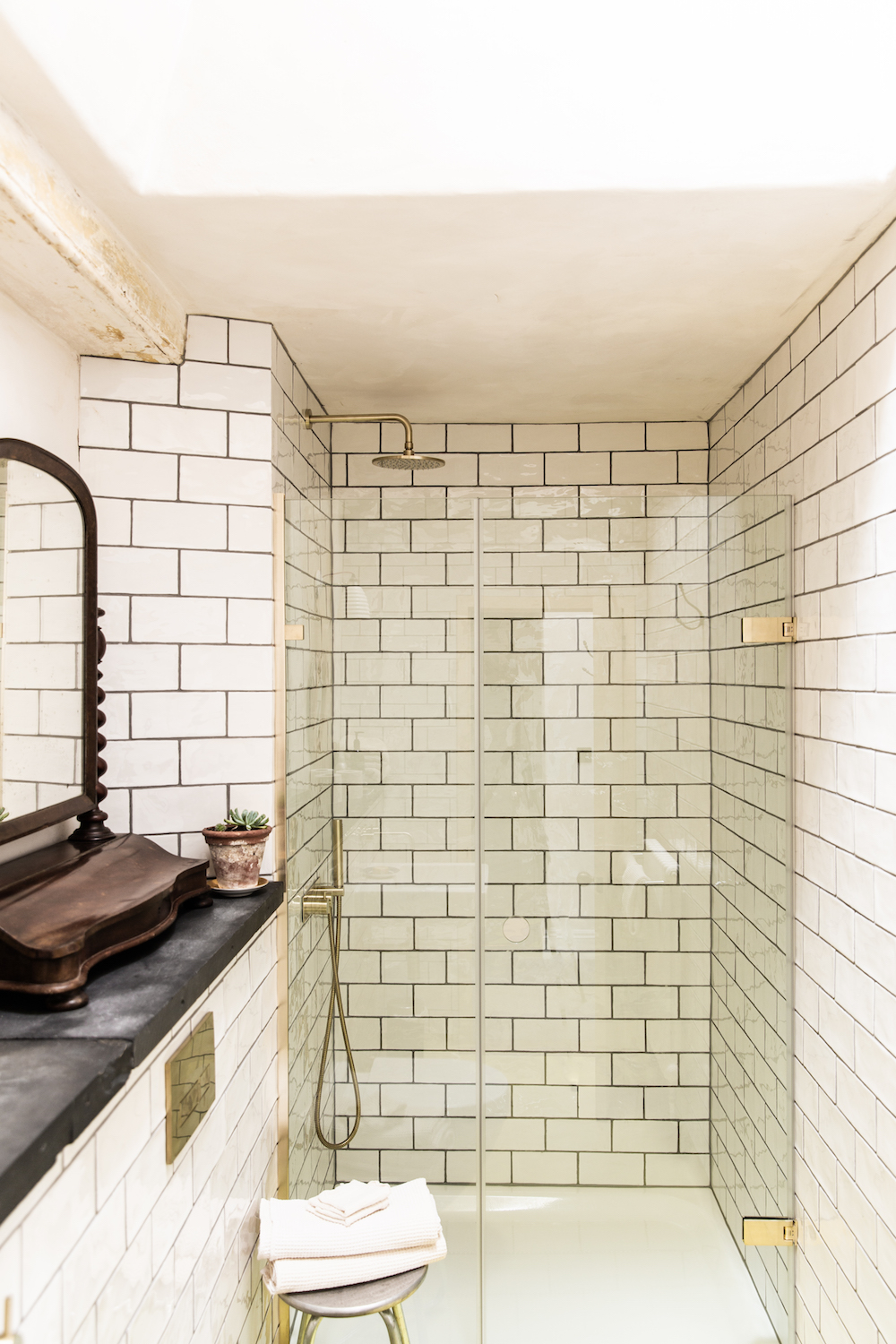 A white brick tiled bathroom with gold shower
