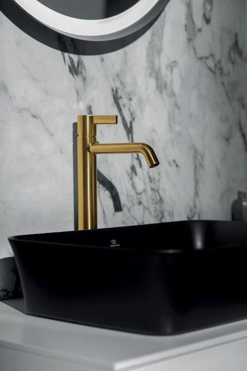 Marble bathroom with gold tap and black basin