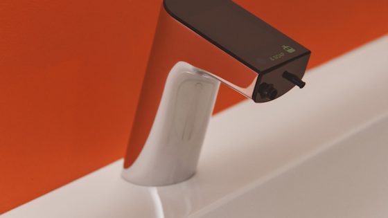 Close-up of a digital tap with orange walls