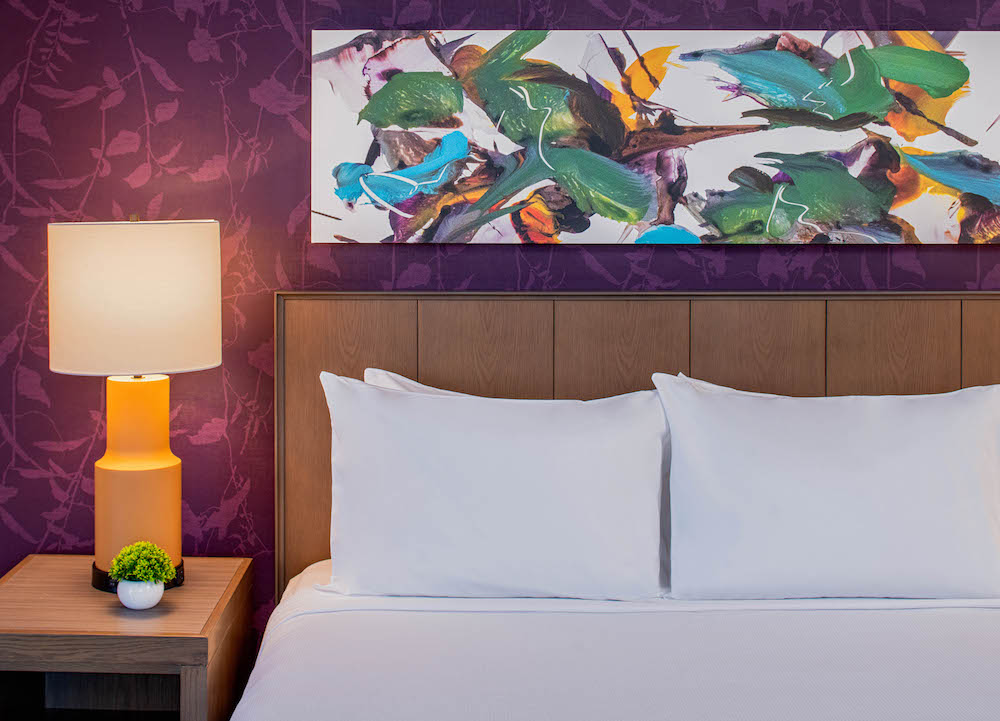 Close up of bed and floral artwork in guestroom