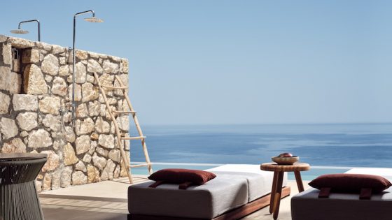 A private outdoor bathroom and sunbeds overlooking sea