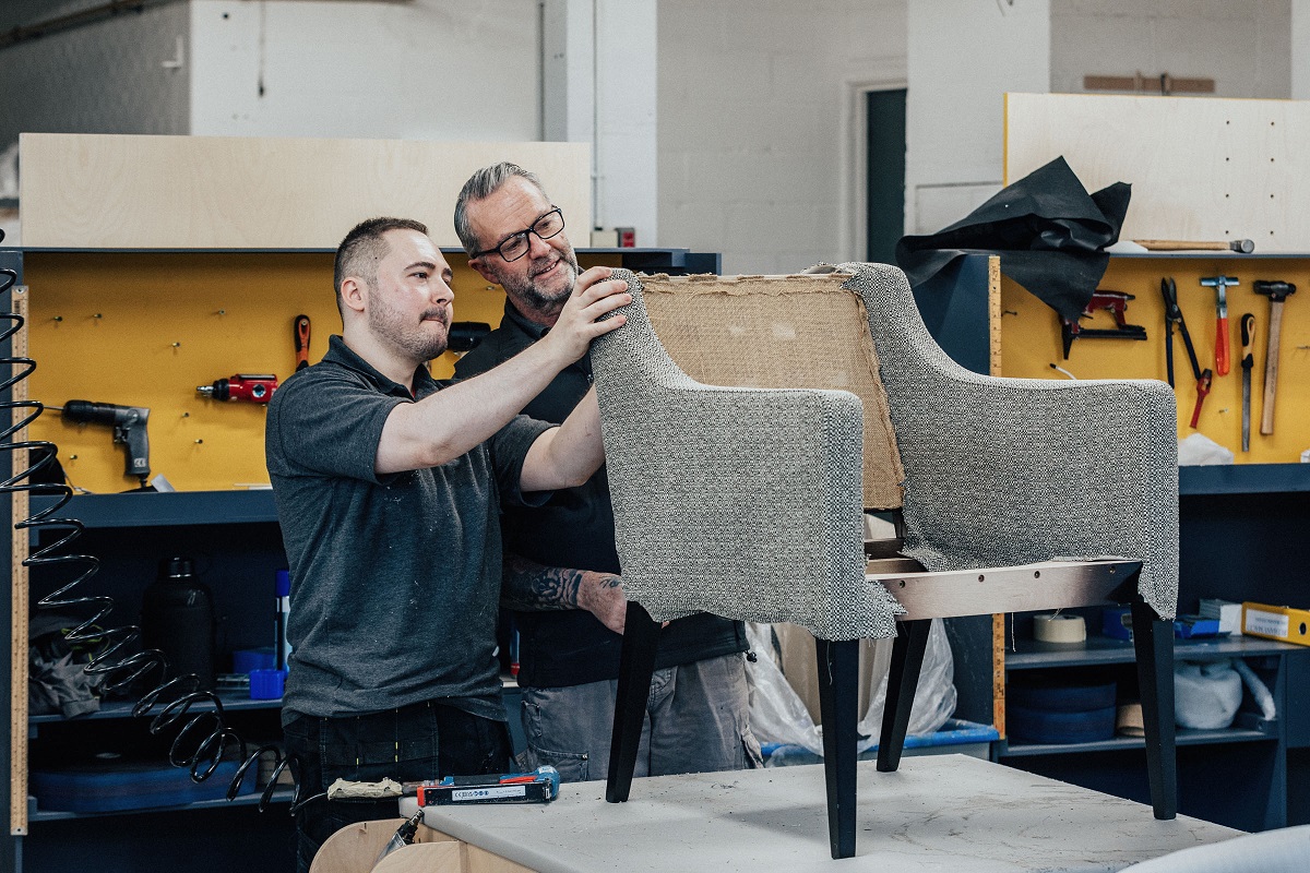 Two men in factory making a chair