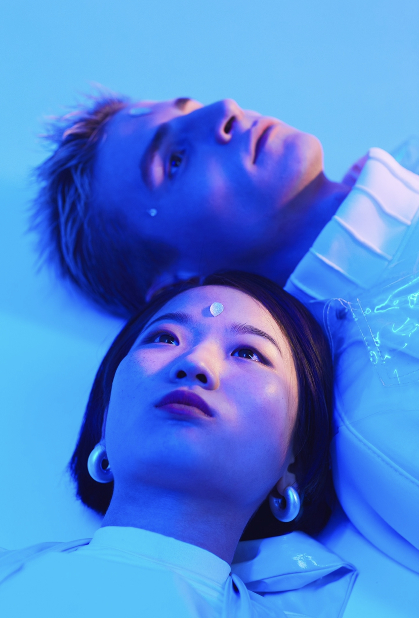 Man and woman under neon lights lying down