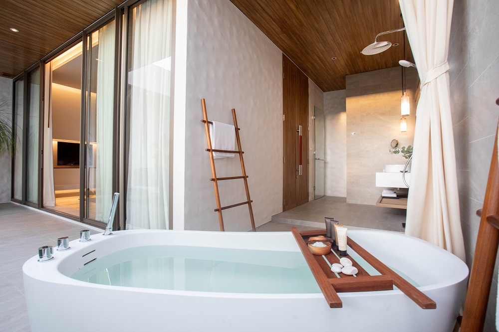outdoor bathroom with freestanding bath and natural materials at melia hotel phuket