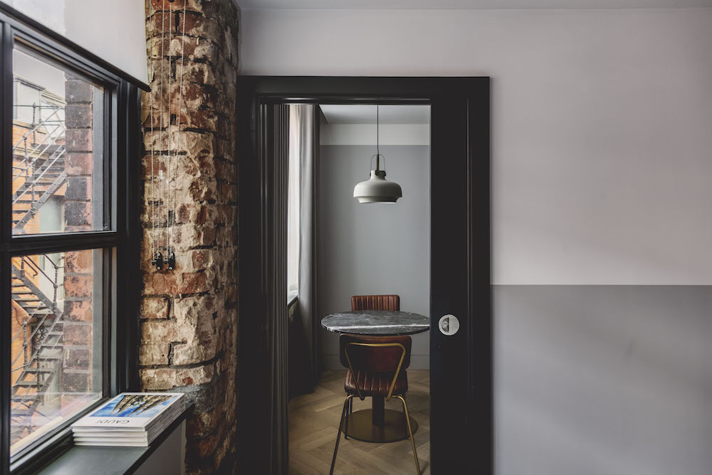 Suite inside LEVEN Manchester, with pendant over table and exposed brick work