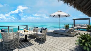 over water villa in the maldives with white parasol and outdoor furniture at conrad maldives rangali