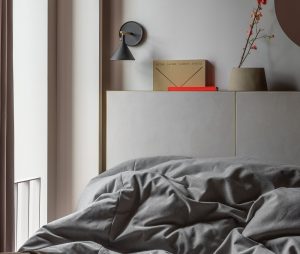 bedroom design at buckle street studios with grey linen and orange accent