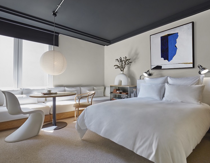 guestroom in white and grey with contemprary art and blue accents at 100 shoreditch