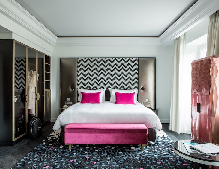 Hotel suite bedroom with pink accents on bed and mosaic floor, in Fauchon L'Hotel Paris