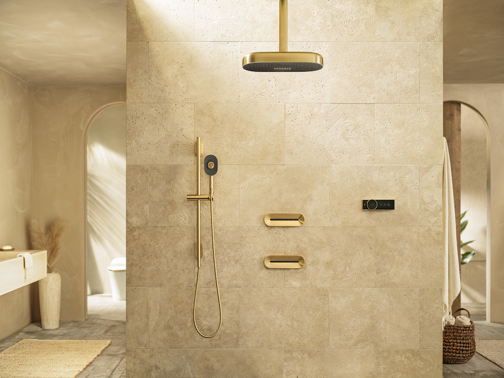 A modern bathroom, with gold Kohler shower items