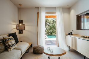 modern and minimalist guestroom overlooking a pool at Minos Beach Art Hotel