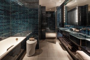 dark blue tiles in boutique bathroom at The Londoner with bath by Bette