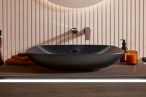 statement black washbasin on wooden surface in the bathroom