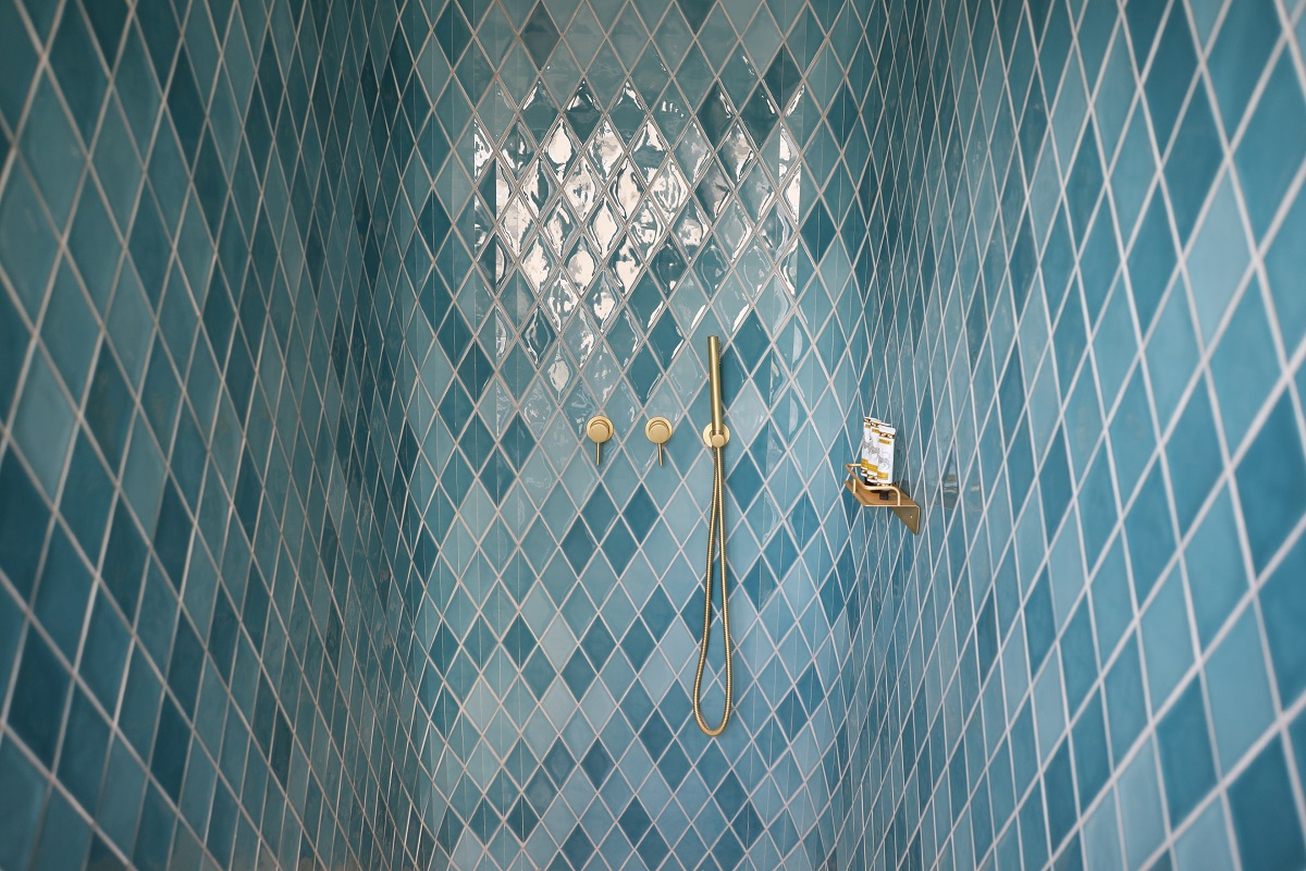 blue tiled shower with brass fittings