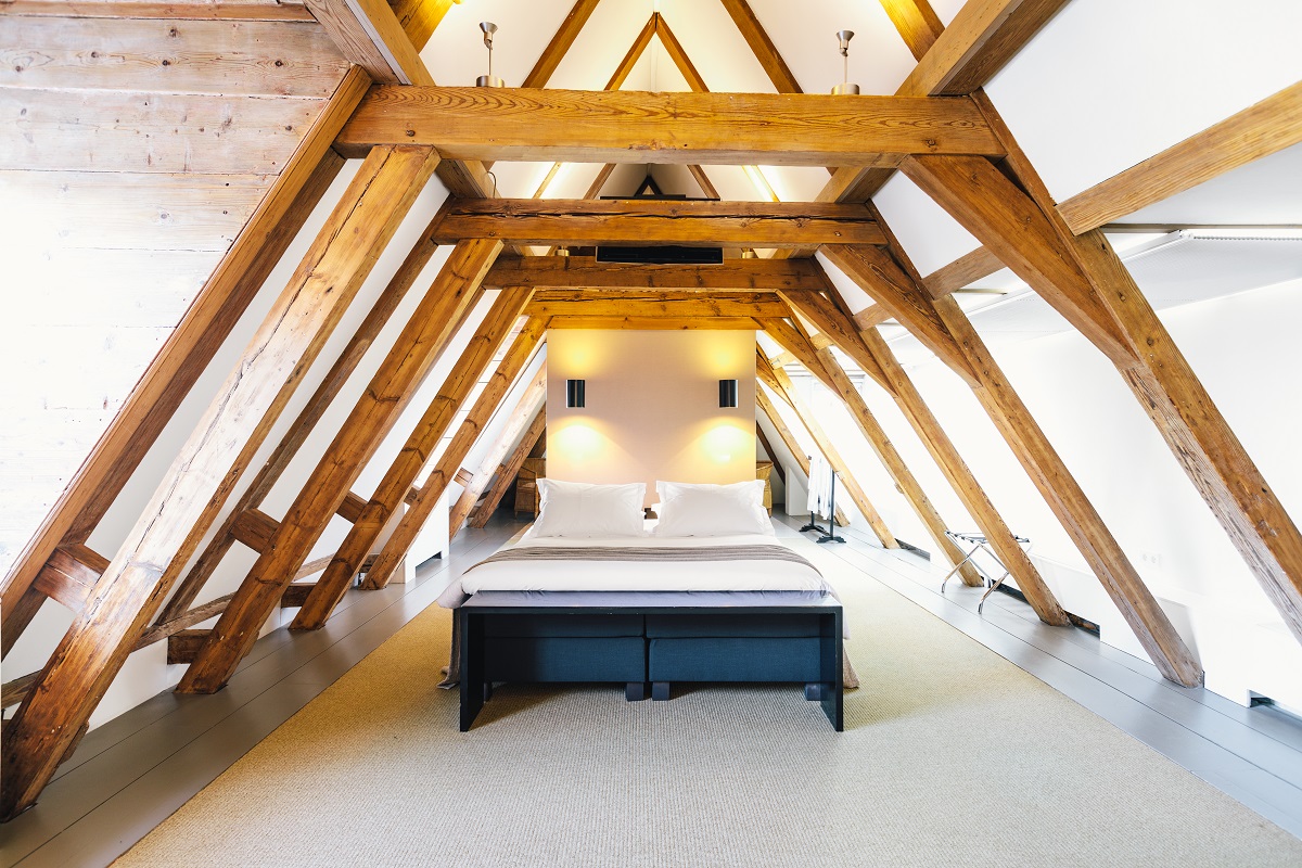 the bed sits under the tradtional beams in the luxury suite