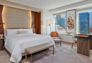 hotel deluxe guest room with natural palette and leather headboard