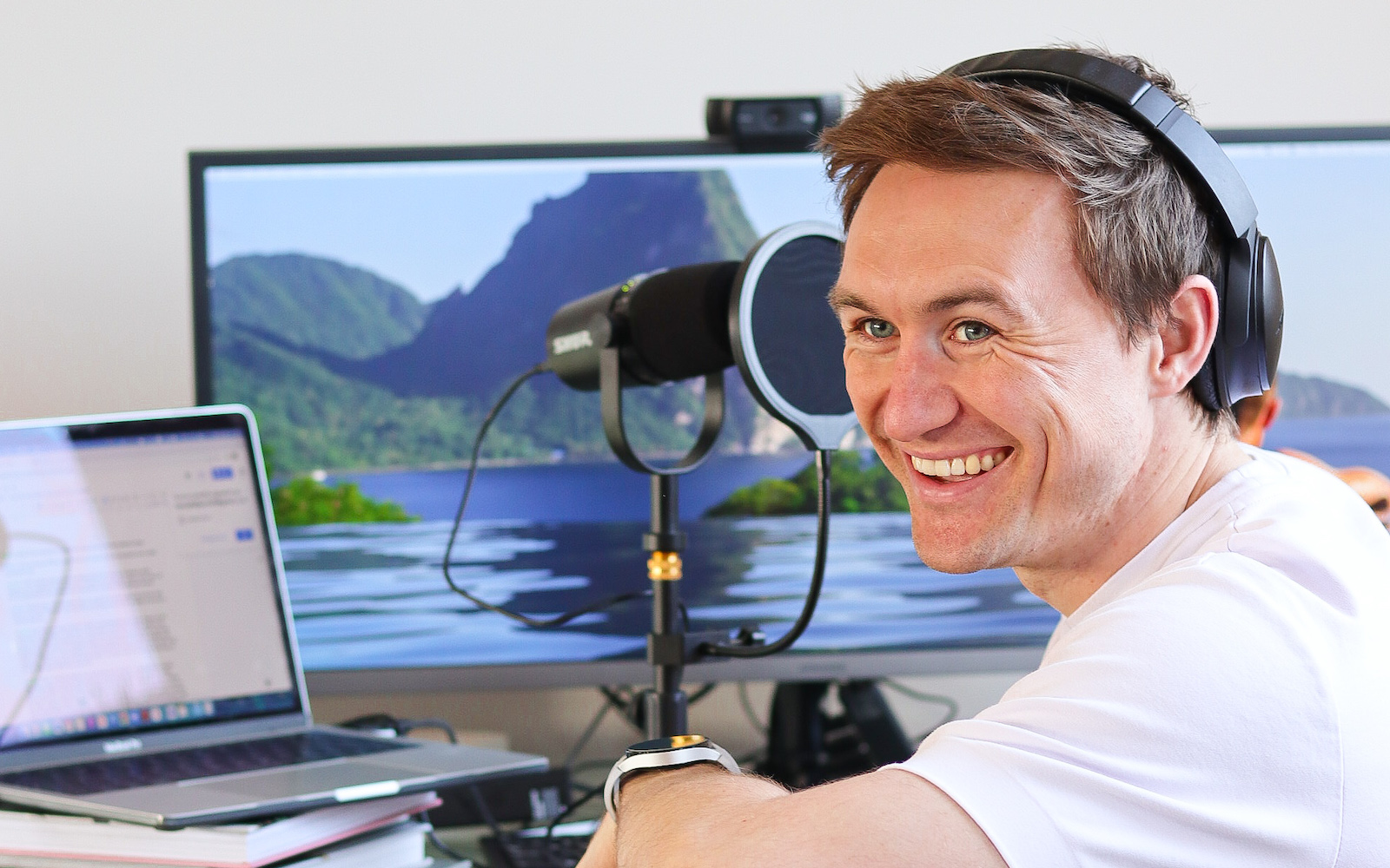Editor Hamish Kilburn in front of a podcast microphone