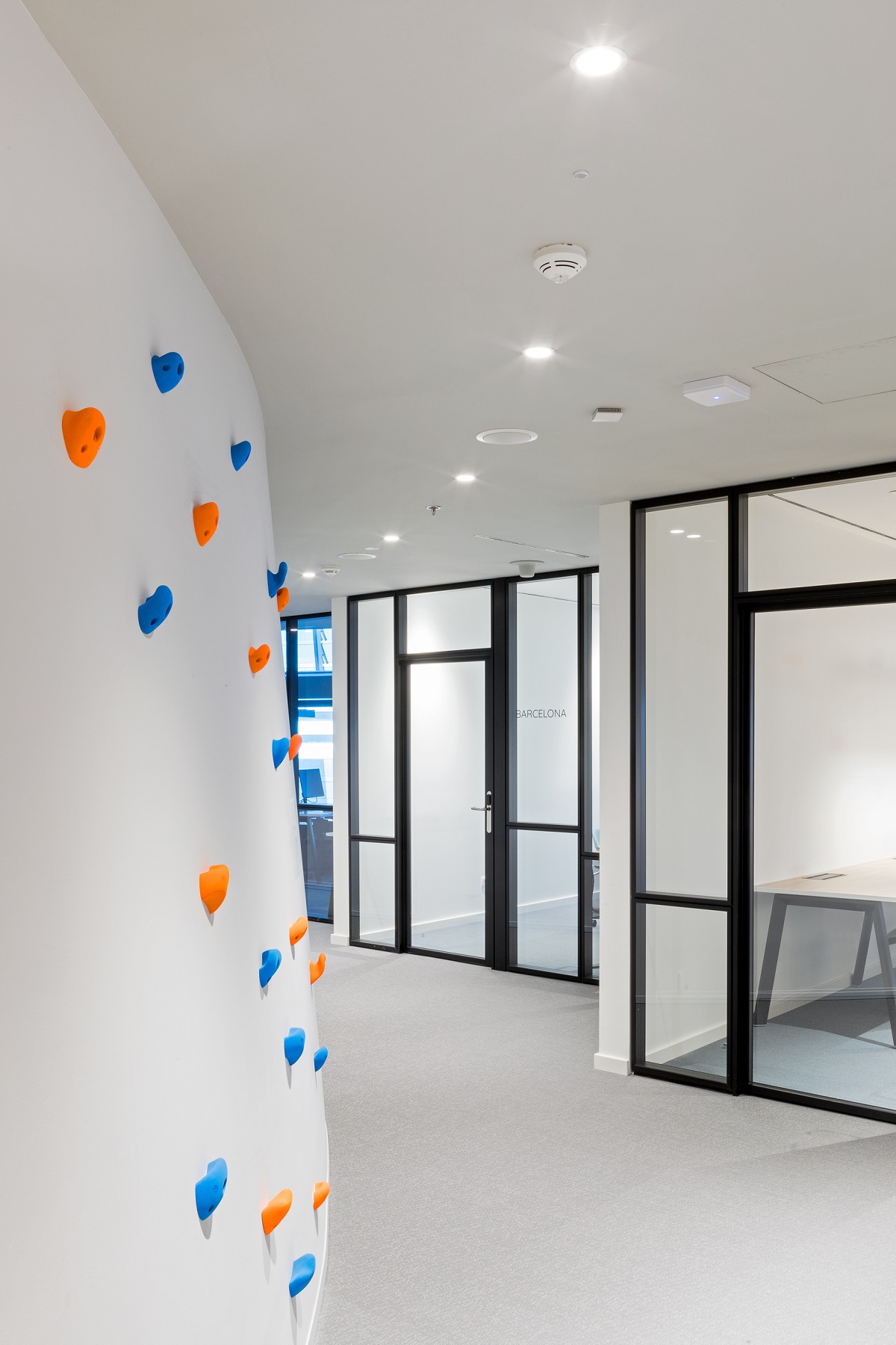 a climbing wall in a communal space with intuitive lighting
