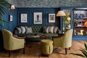 a wallpapered ceiling with olive green velvet with teal blue walls in the public spaces