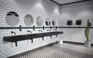 minimalist black and white public bathroom using touchless matt black sensor taps by Crosswater