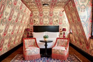 loft style guestroom with walls and ceiling covered in decorative wallpaper