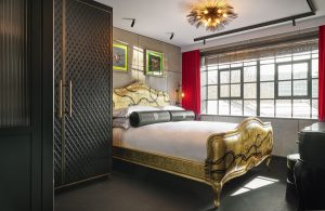 gold leaf headboard with red and black accents in lofthouse guest bedroom