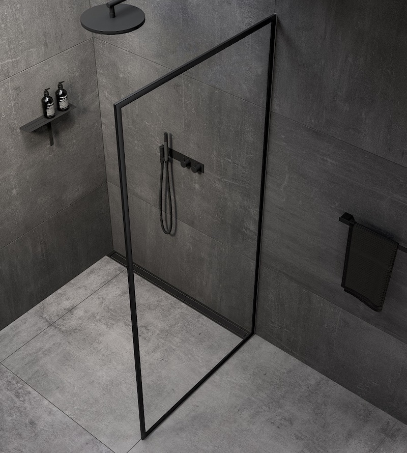 A black framed shower screen in grey industrial bathroom