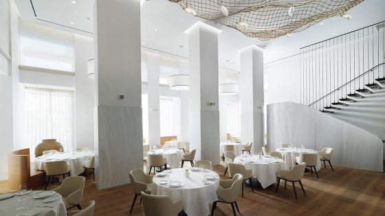 double volume restaurant with white on white decor and sculpture on the ceiling