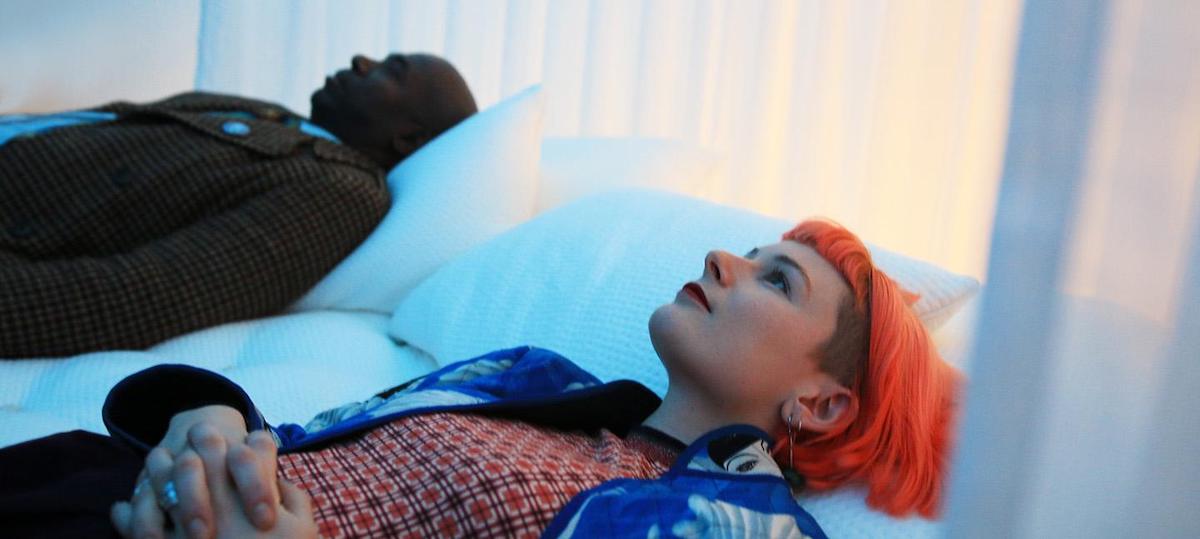 A woman with red hair sleeping next to man