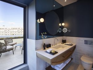 white Greek marble bathroom with dark blue accents looking out over the rooftops of Athens