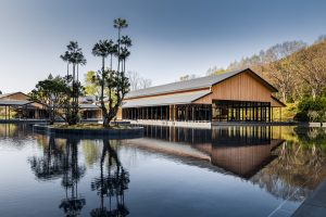 exterior view of hotel ROKU KYOTO looking across the lake to the wooden main structure by Blink Design
