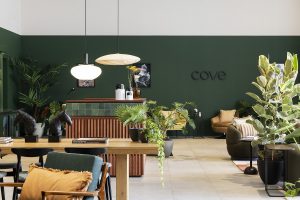 the dark green wall makes a statement backdrop to the communal space in Centrum The Hague