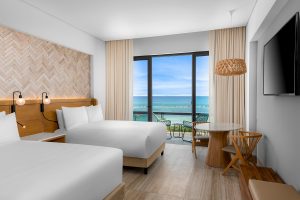 guestroom decorated in natural finishes with a seaview at Hilton Tulum