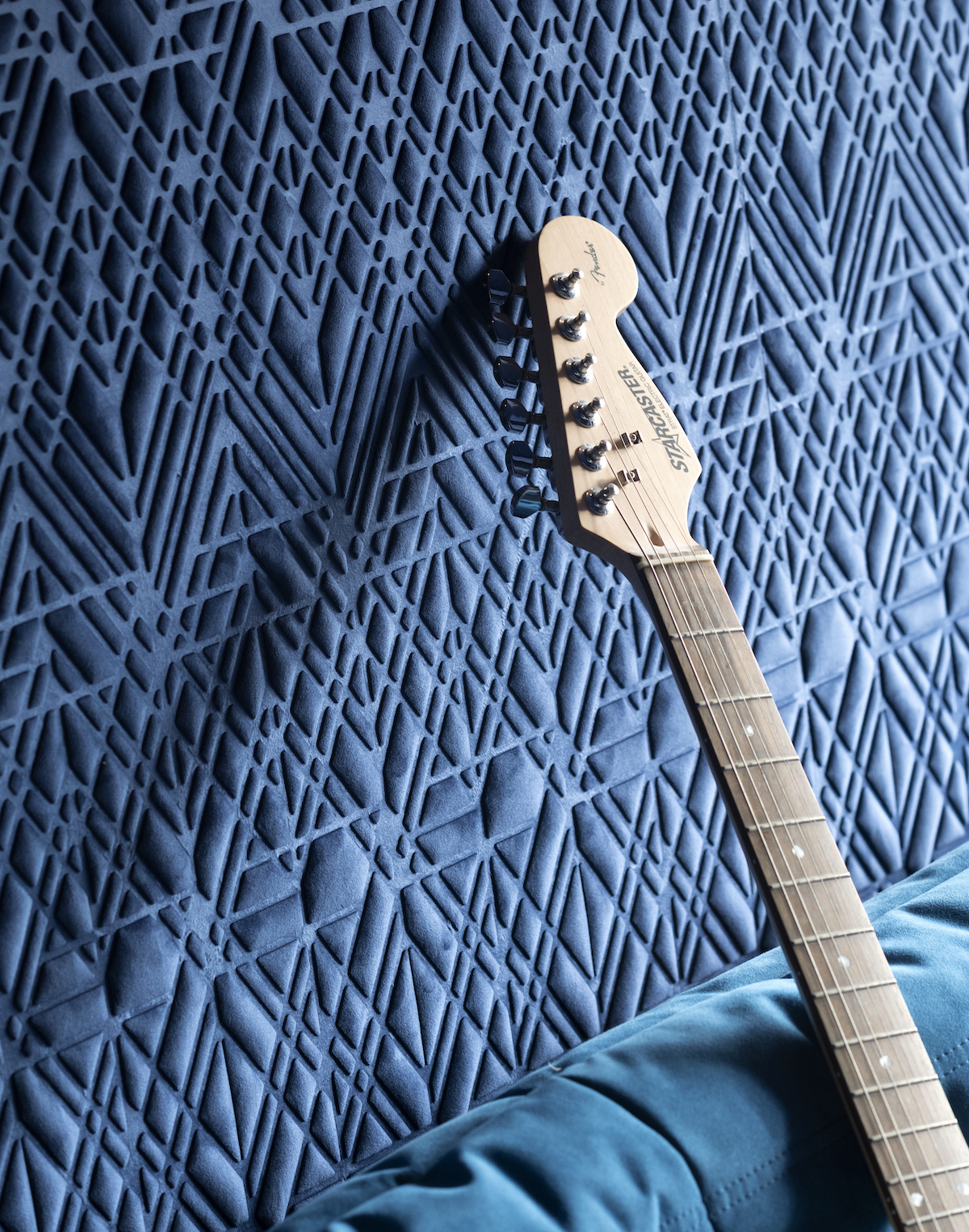 Close up of patterned wall and guitar