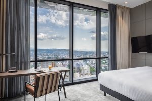 guestroom in the Pullman Tbilisi Axis Towers decorated in shades of grey with panoramic city views