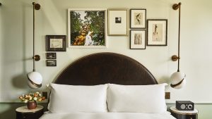 Hotel Per La bed in guestroom with gallery wall and deco inspired lighting