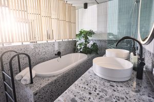 bathroom in the Hotel Seegarten with dornbracht fittings and terrazzo surfaces with wooden slat room divider
