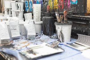 a workbench and tools of the trade - inks and paints used to create designs at Newmor Wallcoverings