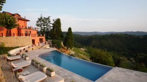 swimming pool and restored farmhouse of boutique hotel Nordelaia in Italy