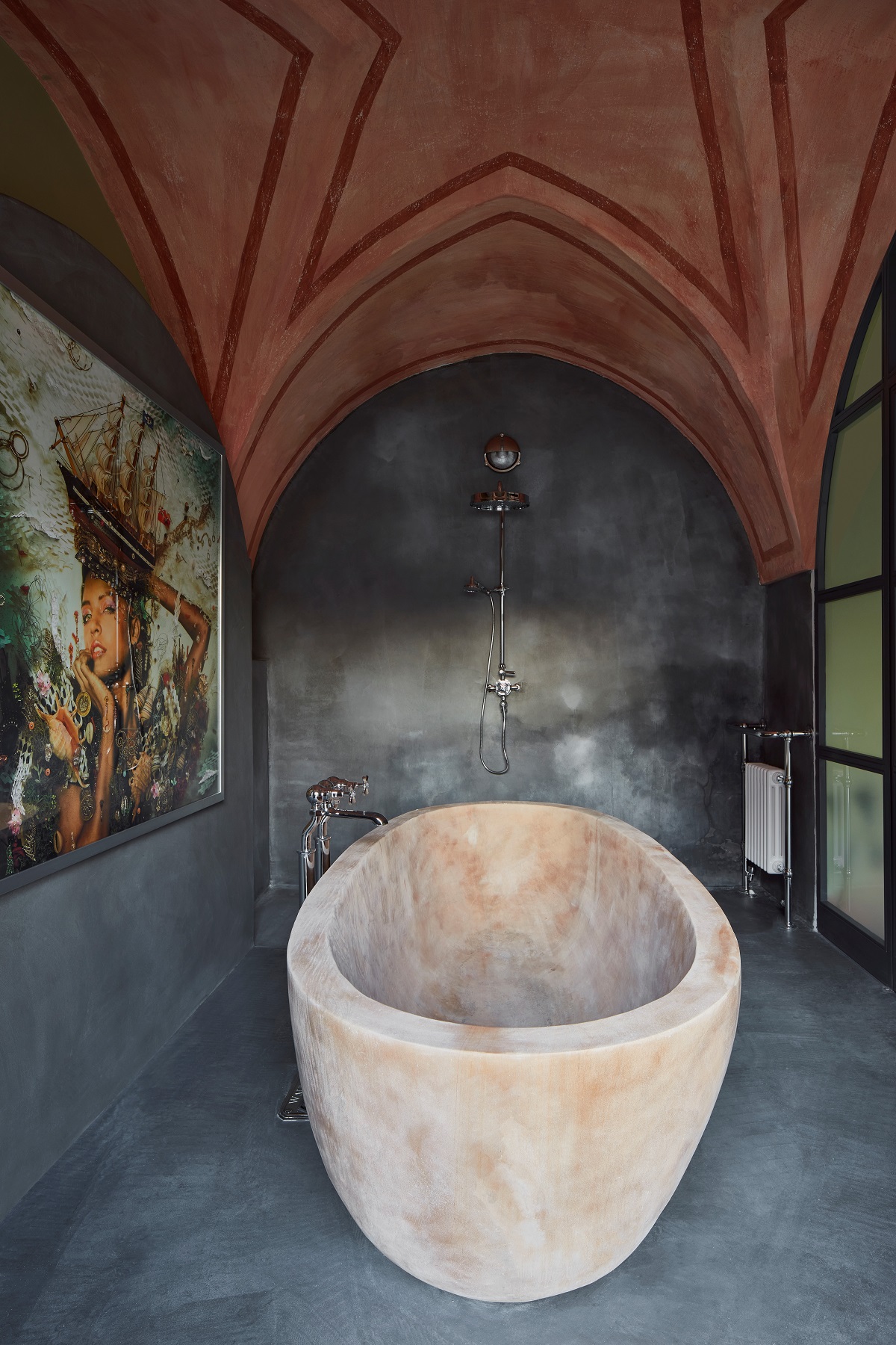 bathroom at Tower elvira with vaulted ceiling, stone bath and original art on the walls