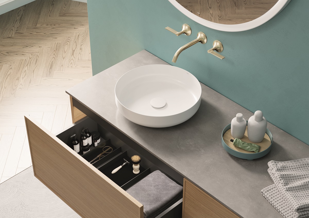 drawer detail with wood finish furniture in blue bathroom with fittings by Alape Arkta from Dornbracht